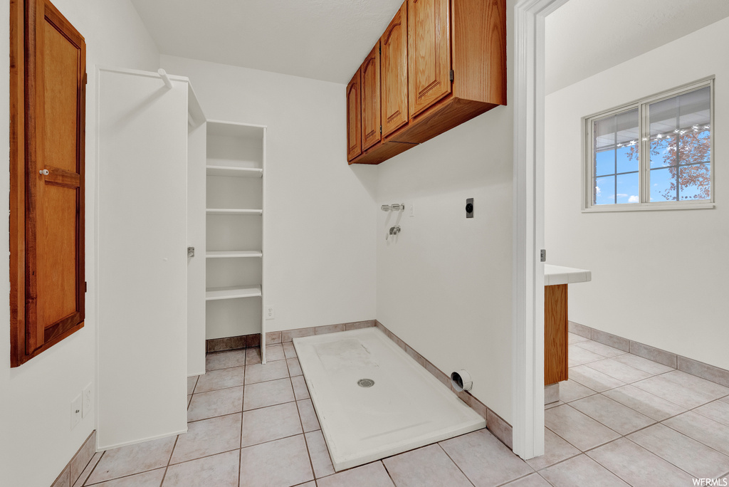 Laundry area featuring hookup for an electric dryer and light tile floors