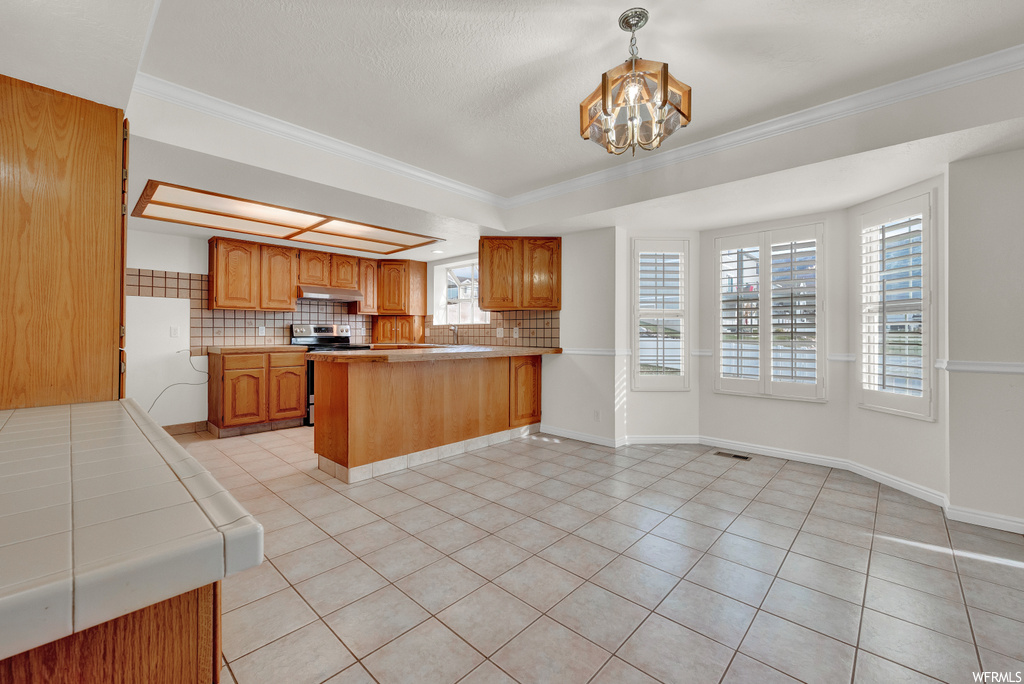 Kitchen featuring a chandelier, white refrigerator, decorative light fixtures, electric stove, and kitchen peninsula