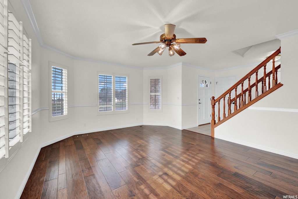 Unfurnished room with ceiling fan, dark hardwood / wood-style flooring, and crown molding
