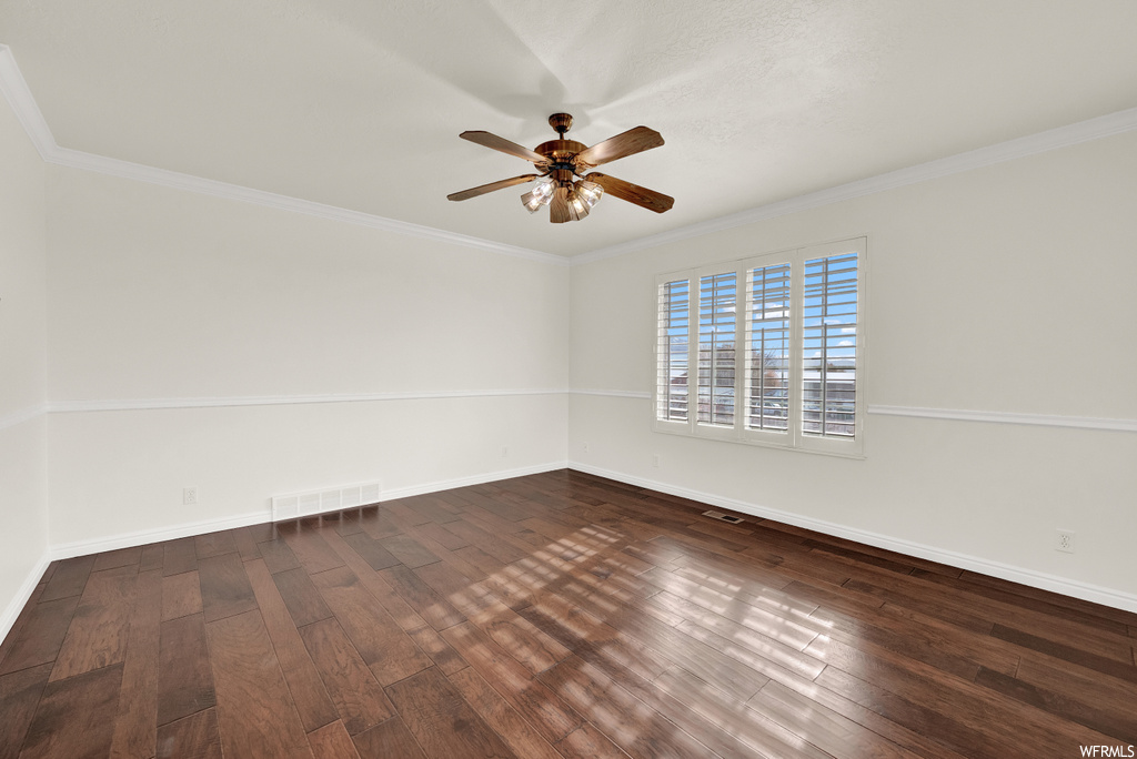 Unfurnished room featuring ornamental molding, dark hardwood / wood-style floors, and ceiling fan
