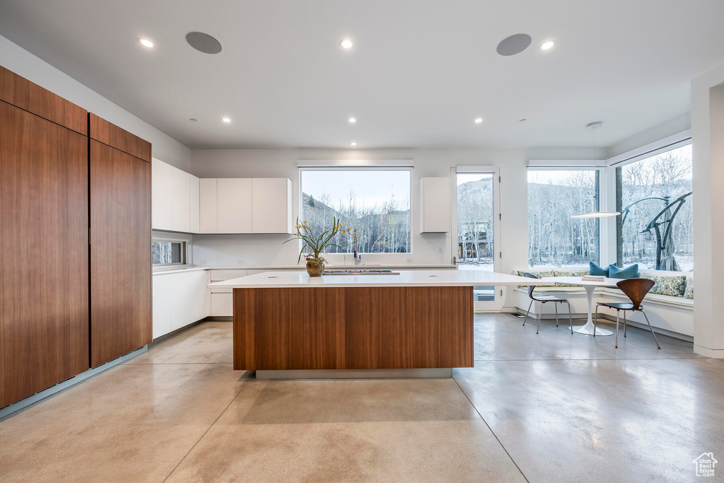 Kitchen featuring white cabinetry, a center island, and a healthy amount of sunlight