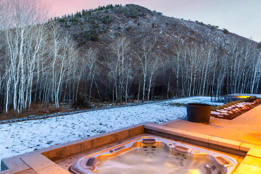 Exterior space featuring a mountain view and an outdoor hot tub