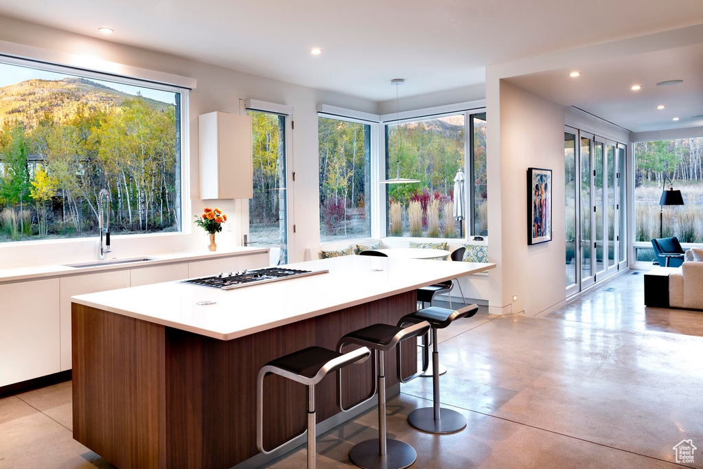 Kitchen featuring a wealth of natural light, white cabinets, and a center island