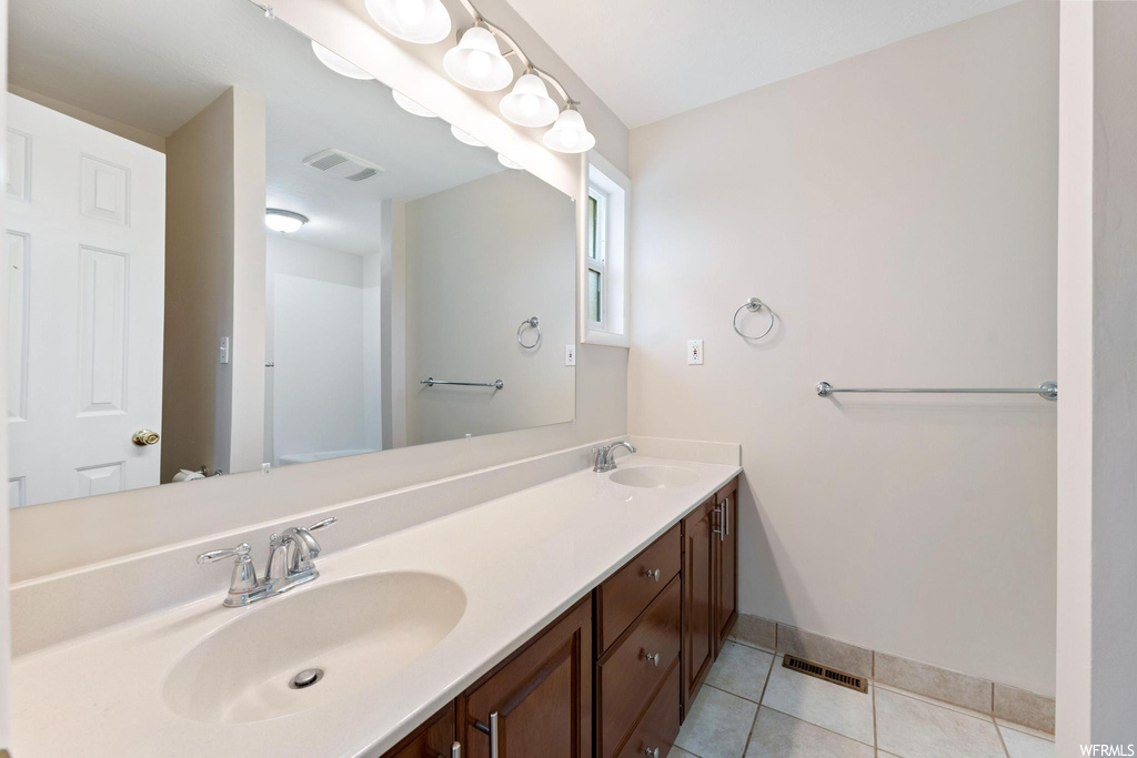 Bathroom featuring tile flooring and dual bowl vanity