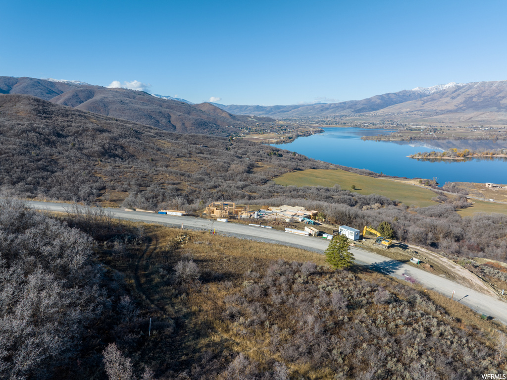 Birds eye view of property with a water and mountain view