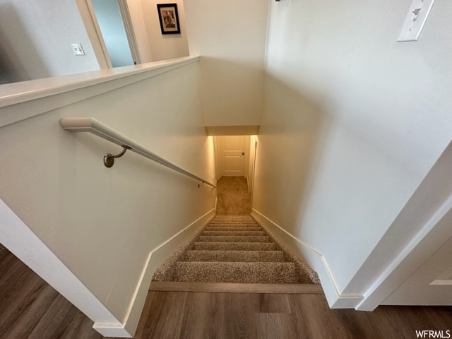 Stairway featuring hardwood / wood-style flooring