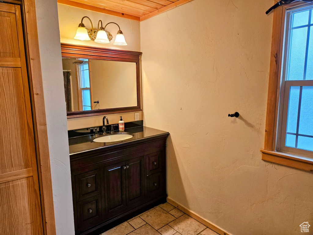 Bathroom featuring tile floors, vanity, and wood ceiling