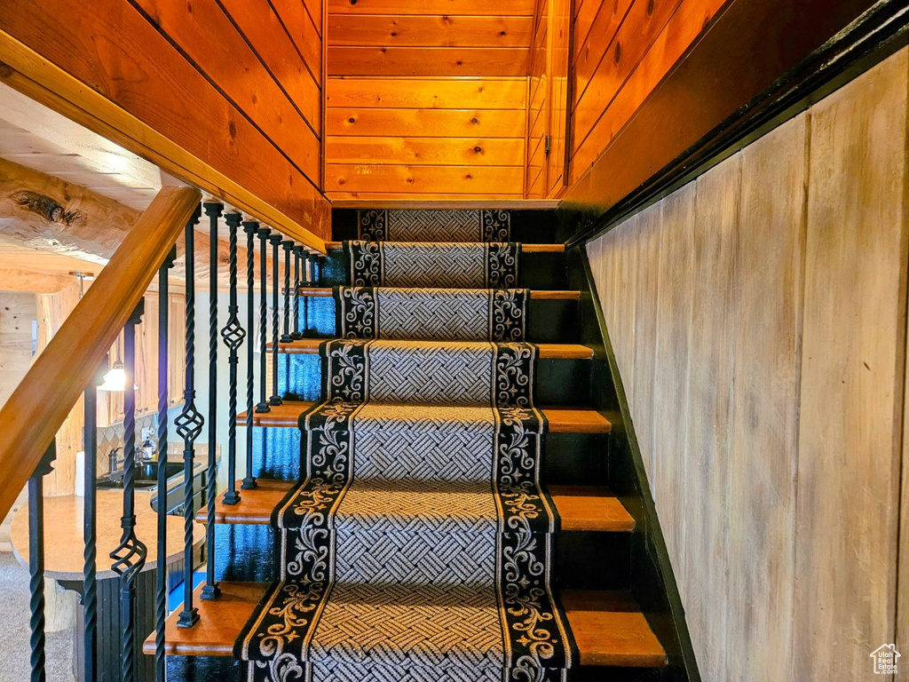 Stairway featuring dark hardwood / wood-style flooring and wooden ceiling