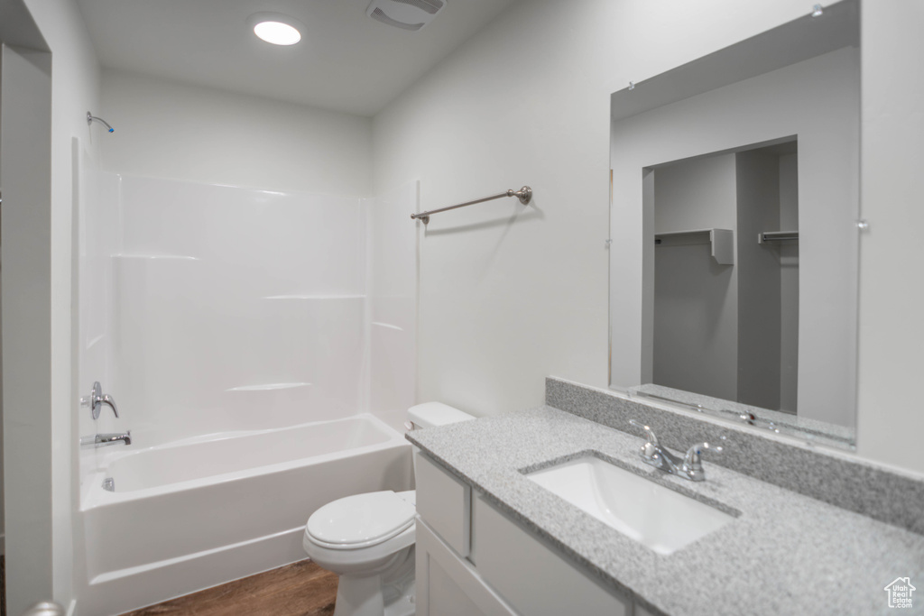 Full bathroom featuring wood-type flooring, toilet, shower / bathing tub combination, and vanity