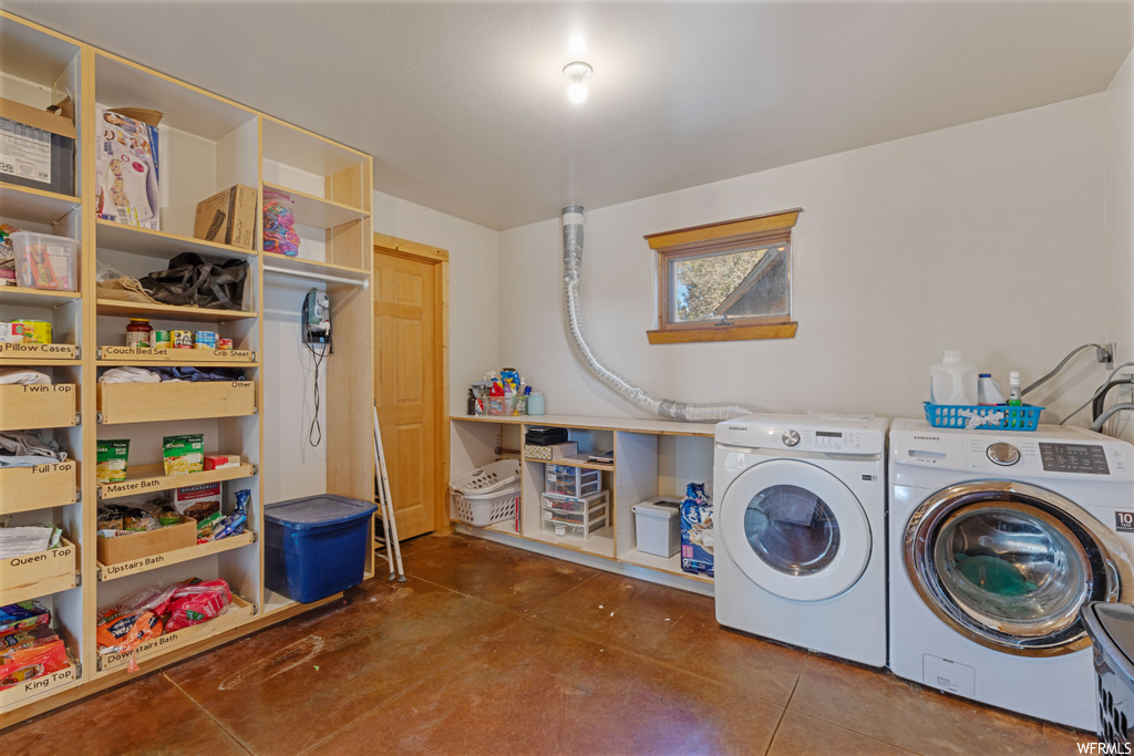 Laundry room featuring dark tile flooring and separate washer and dryer