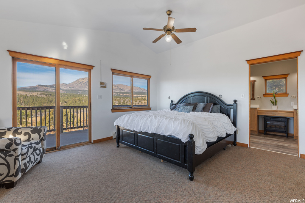 Bedroom featuring multiple windows, vaulted ceiling, access to exterior, ceiling fan, and carpet flooring