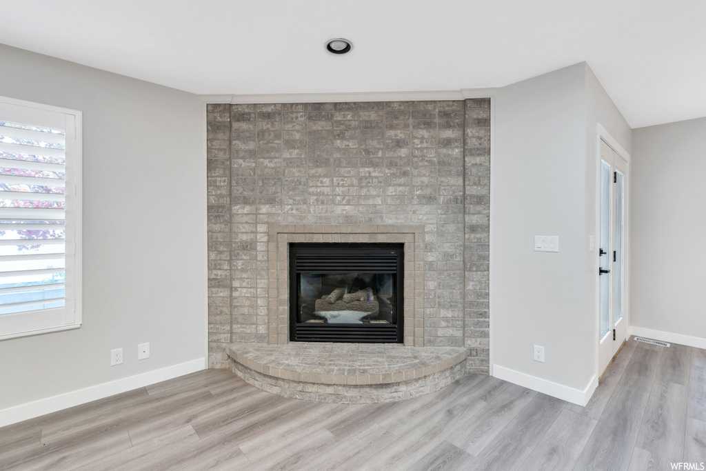 Room details featuring light hardwood / wood-style floors and a brick fireplace