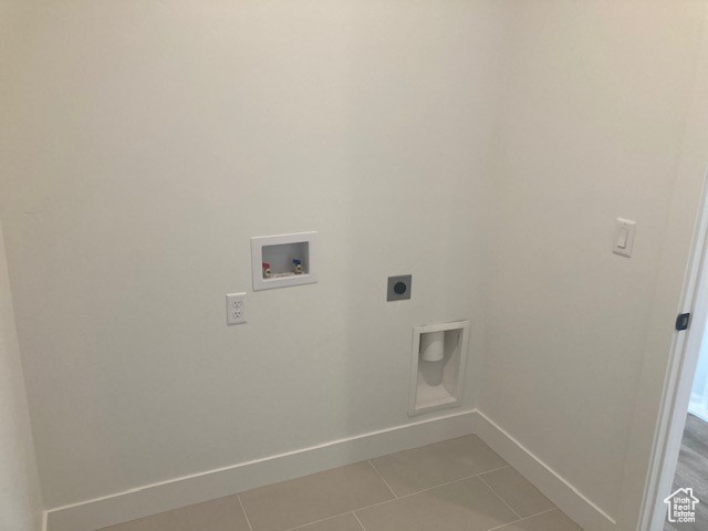 Clothes washing area with light tile flooring, hookup for a washing machine, and hookup for an electric dryer