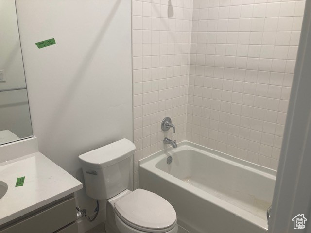 Full bathroom with vanity, toilet, and tiled shower / bath combo