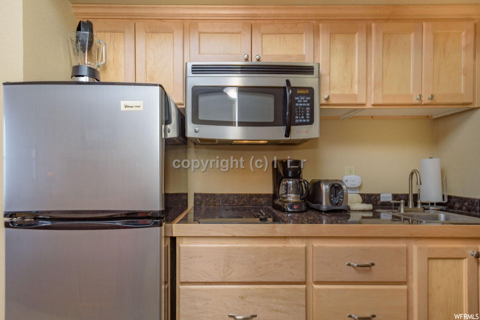 Kitchen with light brown cabinets, sink, and stainless steel appliances