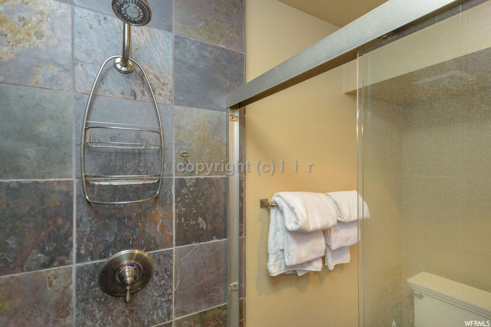 Bathroom featuring toilet and tiled shower