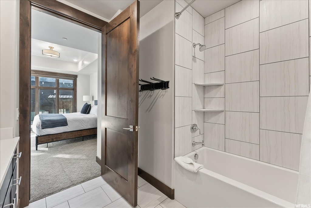 Bathroom featuring shower / bathtub combination, vanity, and tile flooring