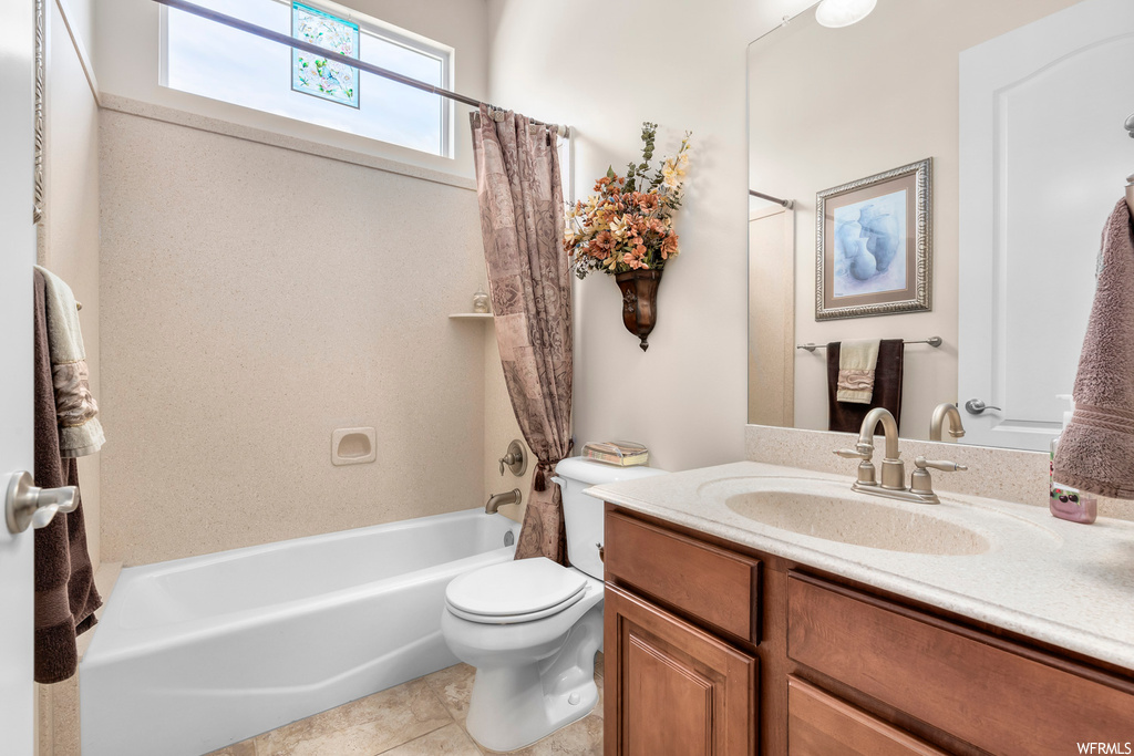 Full bathroom featuring toilet, shower / tub combo, tile floors, and large vanity