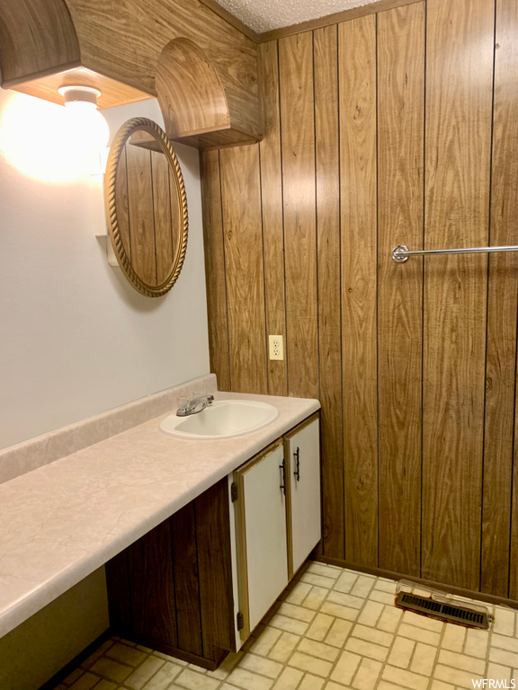 Bathroom featuring wood walls and large vanity