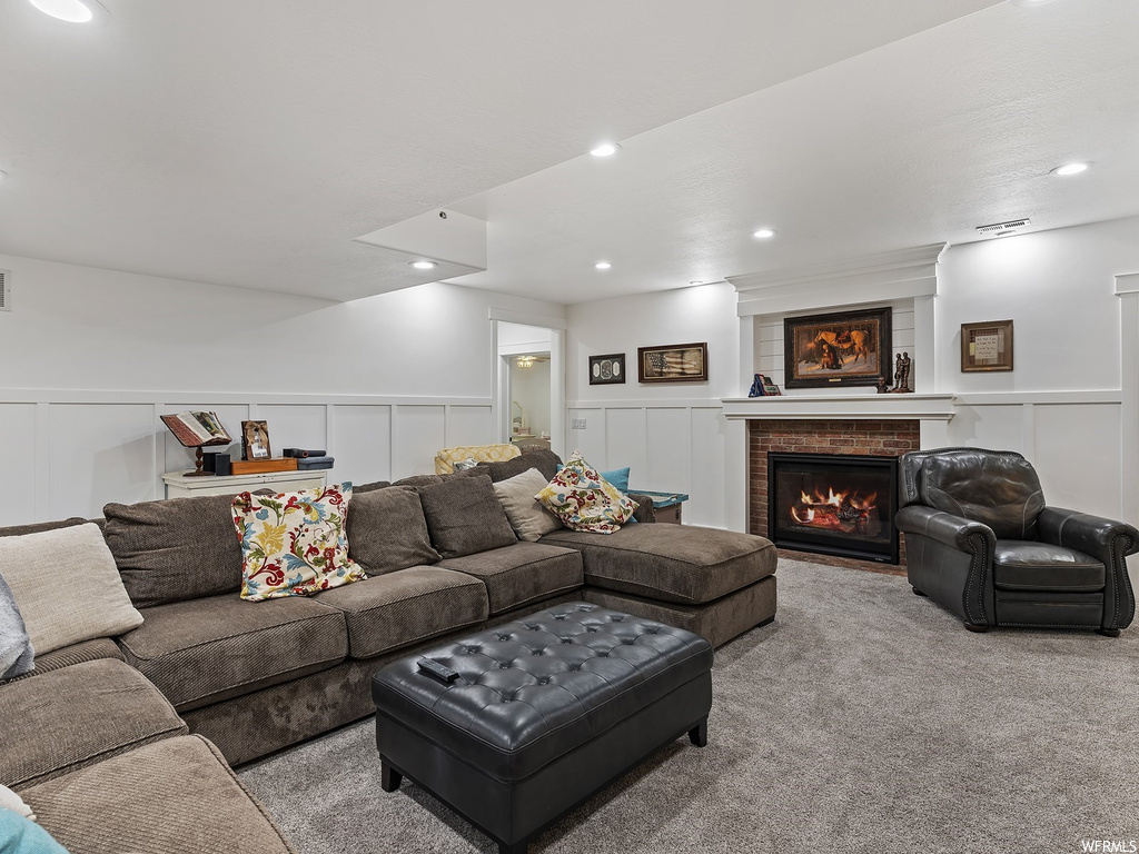 Carpeted living room featuring a brick fireplace