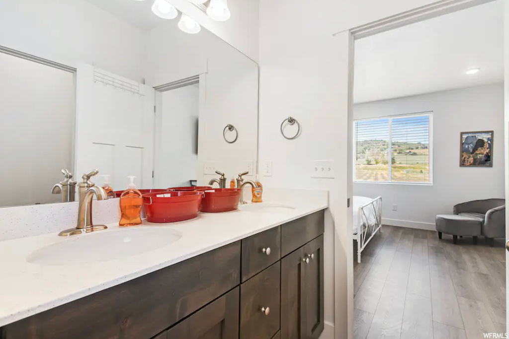 Bathroom with oversized vanity, double sink, and hardwood / wood-style floors
