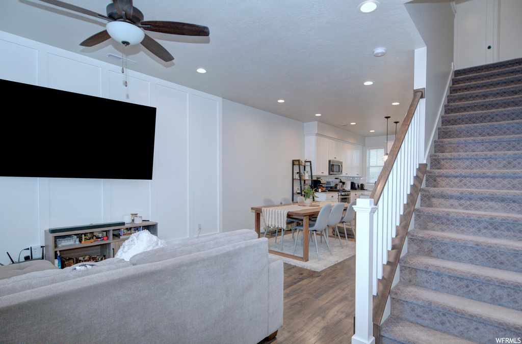 Living room featuring ceiling fan and hardwood / wood-style flooring
