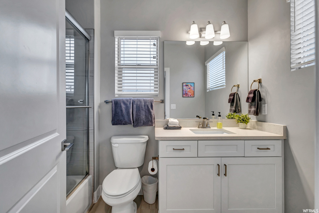 Full bathroom featuring toilet, enclosed tub / shower combo, and oversized vanity