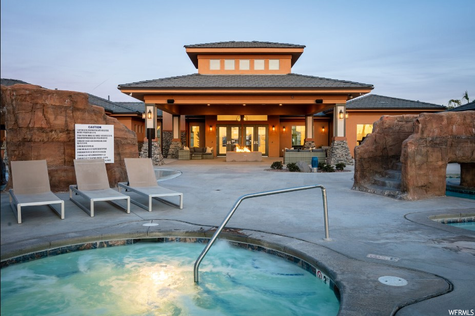 Pool at dusk with a community hot tub and a patio area