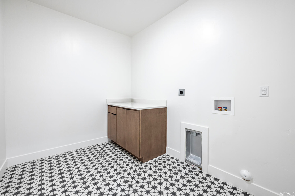 Laundry area with hookup for a gas dryer, hookup for a washing machine, electric dryer hookup, and light tile floors