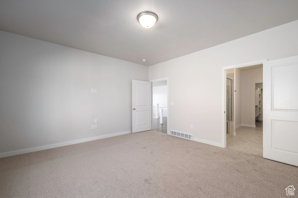 Unfurnished bedroom with light colored carpet