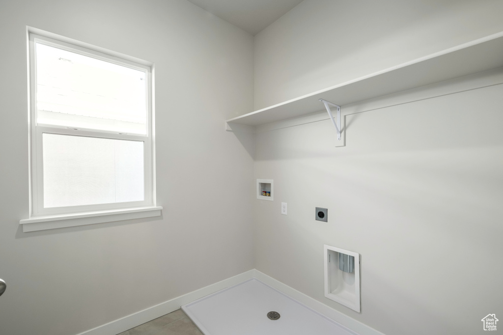 Clothes washing area with hookup for a washing machine, tile flooring, and hookup for an electric dryer