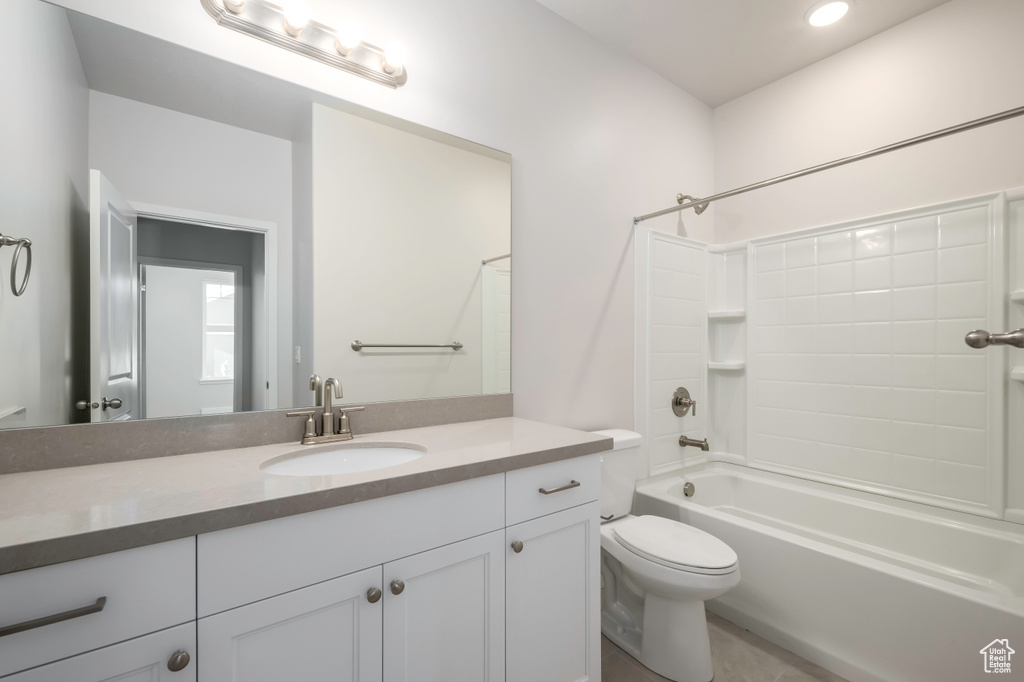 Full bathroom with toilet, oversized vanity, and shower / bathing tub combination