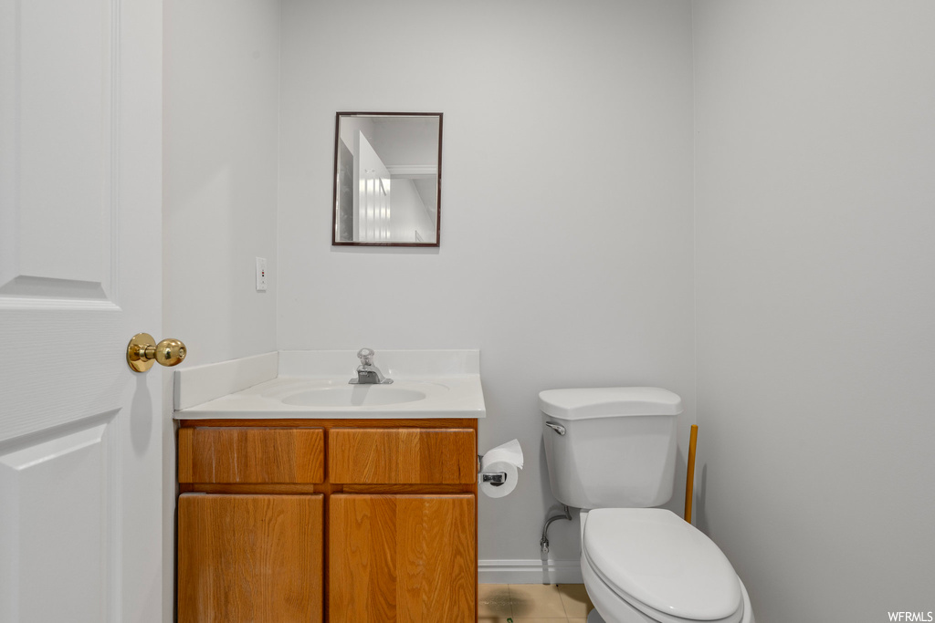 Bathroom with toilet, tile floors, and vanity