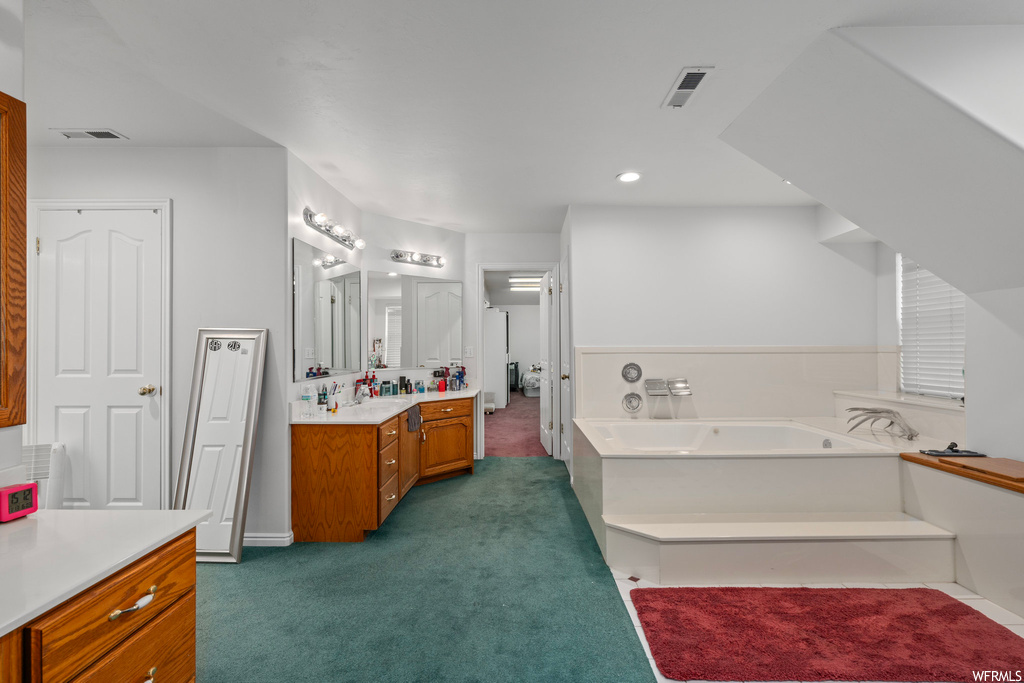 Bathroom featuring a bath and vanity with extensive cabinet space