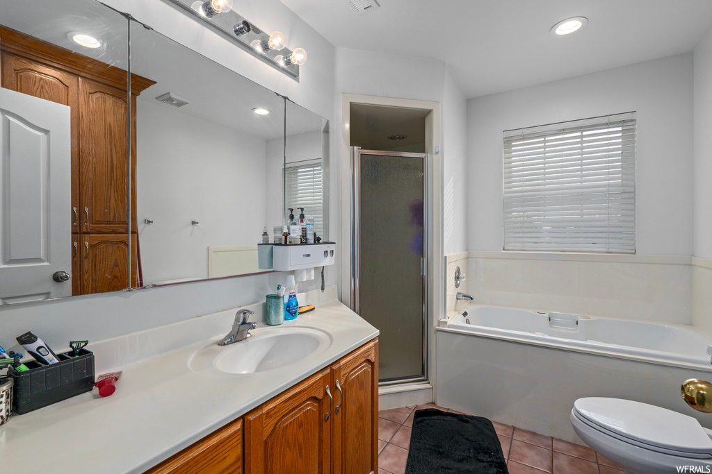 Full bathroom with separate shower and tub, toilet, tile flooring, and large vanity