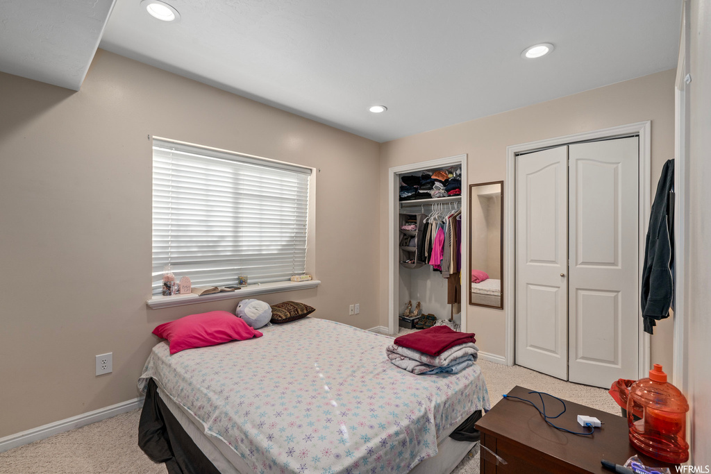 Bedroom with multiple closets and light carpet