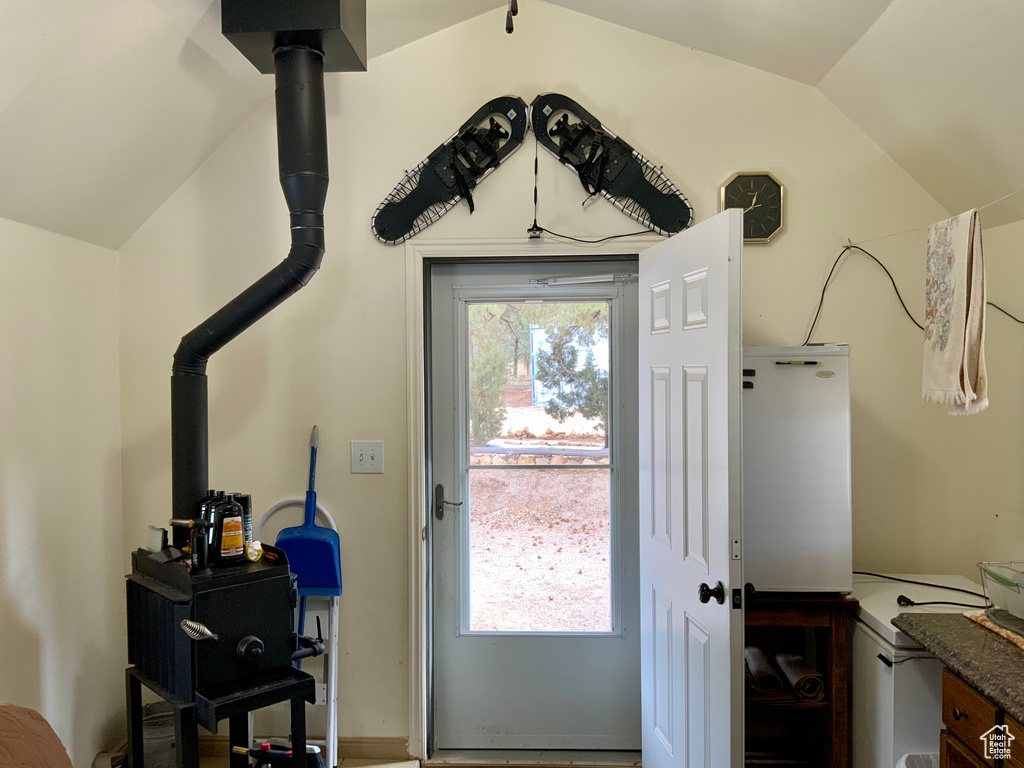 Doorway to outside featuring lofted ceiling