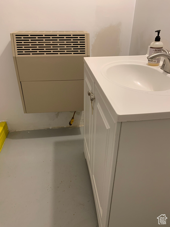 Bathroom with vanity, concrete flooring, and radiator heating unit