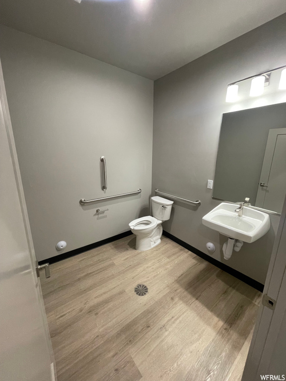 Bathroom featuring toilet, sink, and hardwood / wood-style floors