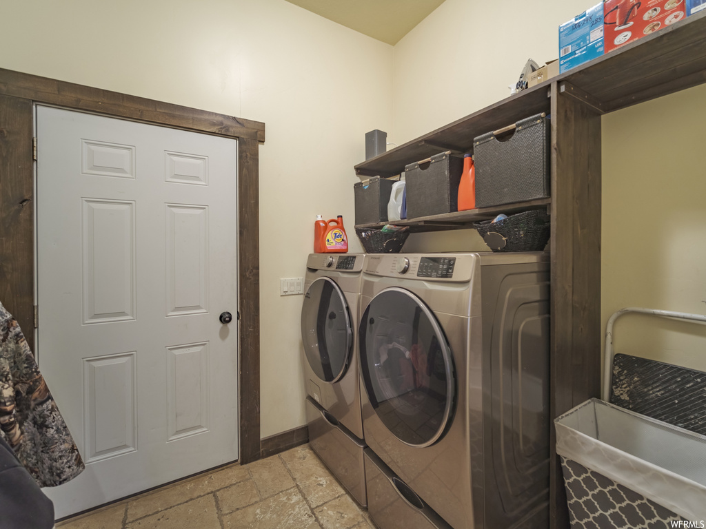Laundry area with washer and dryer and light tile flooring