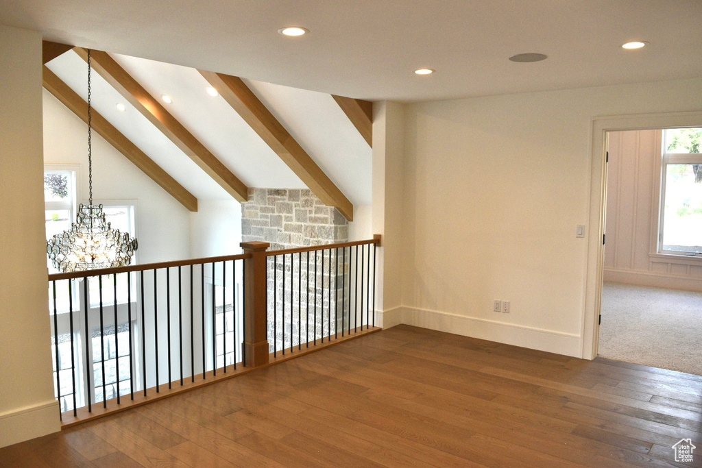 Interior space featuring vaulted ceiling with beams, carpet, and a chandelier