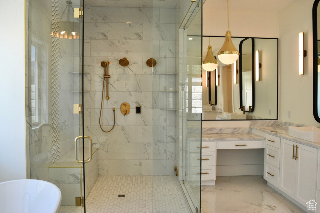 Bathroom featuring vanity, tile patterned floors, and shower with separate bathtub