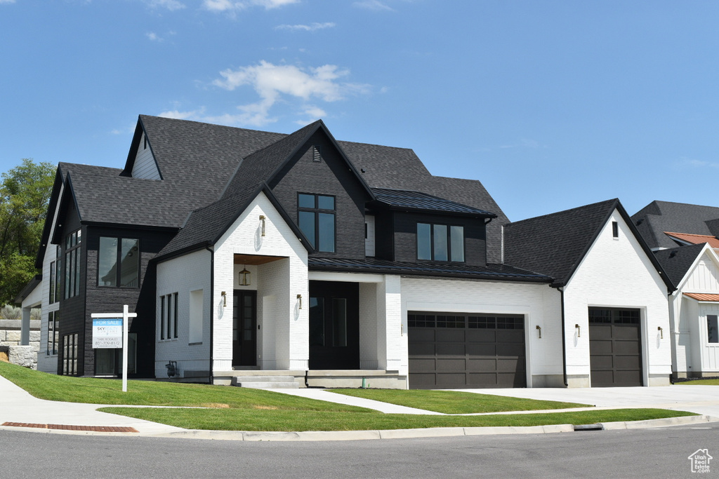 View of front of house featuring a garage and a front yard