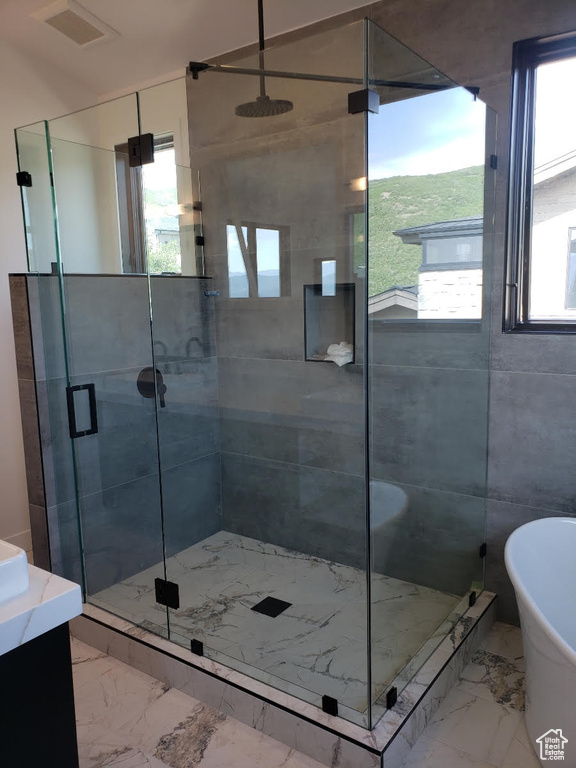 Bathroom featuring vanity, plus walk in shower, and tile patterned flooring