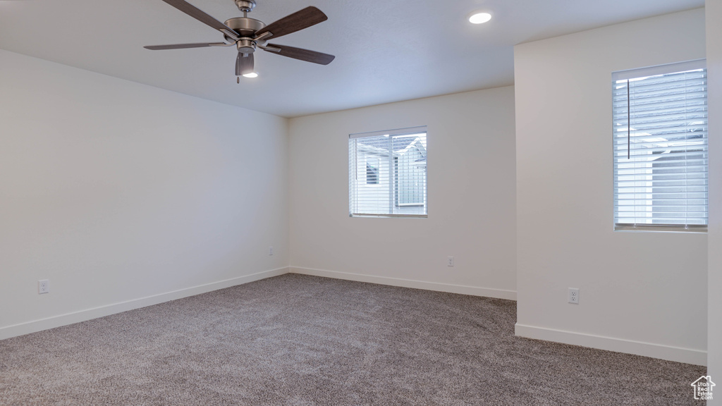 Carpeted spare room with a healthy amount of sunlight and ceiling fan