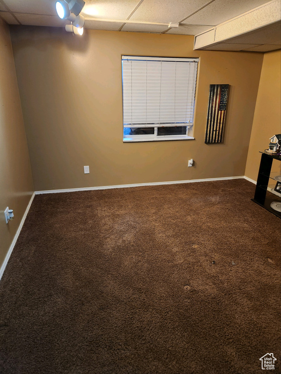 Empty room featuring a paneled ceiling and carpet