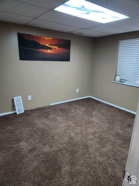 Unfurnished room with carpet floors and a drop ceiling