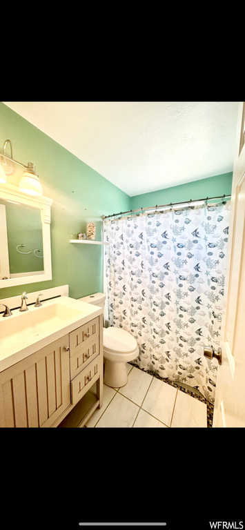 Bathroom featuring toilet, tile flooring, and oversized vanity