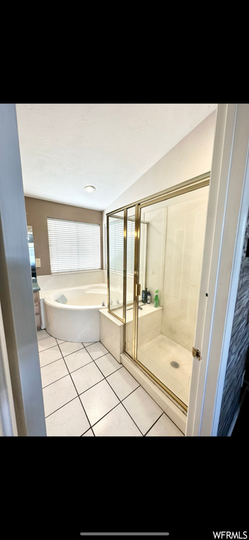 Bathroom featuring tile flooring and plus walk in shower