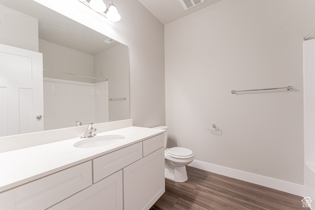 Bathroom featuring oversized vanity, hardwood / wood-style flooring, and toilet